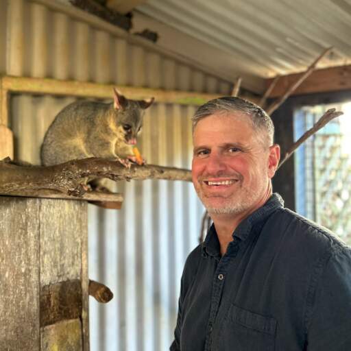 A smiling man with a native marsupial